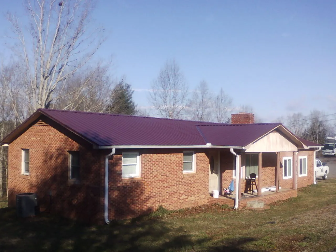 Burgundy metal roof on a brick ranch home with a new addition in Bechtelsville