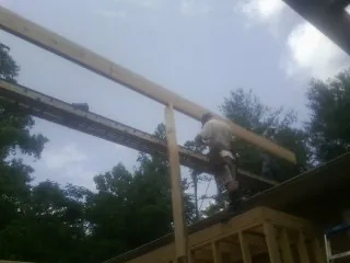 Carpenter setting a ridge beam over a new addition frame — Ice Dam Removal by Roofing Brothers in Bechtelsville