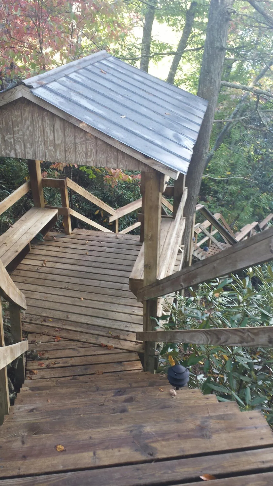 Metal roofed shelter over wooden steps on a wooded walkway — Skylight Repair & Installation work by our crew in Bechtelsville